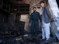 An Afghan policeman and a local resident inspect a burnt shop at the site of a car bomb attack in western Kabul on July 24, 2017. At least 24 people have been killed and 42 wounded after a car bomb struck a bus carrying government employees in western Kabul on July 24, an official told AFP, the latest attack to strike the Afghan capital. / AFP PHOTO / WAKIL KOHSAR (Photo credit should read WAKIL KOHSAR/AFP/Getty Images)