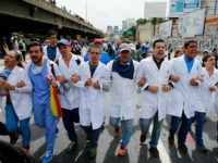 Doctors march during an anti-government protest demanding that Venezuelan President Nicolas Maduro open a so-called humanitarian corridor for the delivery of medicine and food aid, in Caracas, Venezuela, Monday, May 22, 2017. At least 46 people have died during the two-month anti-government protest movement. (AP Photo/Ariana Cubillos)