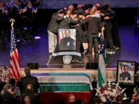 The family of New York City Police officer Miosotis Familia hug during her funeral at the World Changers Church, in The Bronx borough of New York, Tuesday, July 11, 2017. The slain officer, a mother of three children including 12-year-old twins, was writing in her memo book at the end of her shift early last Wednesday when a man walked up to the police vehicle where she was sitting and fired. (AP Photo/Richard Drew, Pool)
