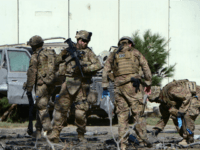US soldiers inspect the site of a suicide attack in the Afghan capital Kabul on September 16, 2014. A Taliban suicide bomber rammed an explosives-laden car into a NATO convoy close to the US embassy in Kabul on September 16, killing three soldiers and wounding at least 13 Afghan civilians. At the side of the road, US and Polish troops gave first-aid to blood-stained comrades beside the wrecked remains of a military vehicle, but the nationality of the dead soldiers was not confirmed. AFP PHOTO/Wakil Kohsar (Photo credit should read WAKIL KOHSAR/AFP/Getty Images)