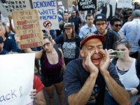 PHOENIX, AZ - AUGUST 22: Protesters outside the Phoenix Convention Center hold up anti-President Donald Trump signs and shout back at Trump supporters waiting to enter a rally by Trump on August 22, 2017 in Phoenix, Arizona. An earlier statement by the president that he was considering a pardon for Joe Arpaio,, the former sheriff of Maricopa County who was convicted of criminal contempt of court for defying a court order in a case involving racial profiling, has angered Latinos and immigrant rights advocates. (Photo by Ralph Freso/Getty Images)