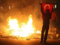 A protestor holds a national flag of Turkey during a demonstration in Ankara, early on June 3, 2013, in a nationwide wave of protests.Turkey's Islamist-rooted government faced growing pressure on June 3 after angry demonstrators clashed for a third night with police. The unrest began as a local outcry against plans to redevelop Gezi Park, a rare green spot near Taksim, but after a heavy-handed police response the protests spread to other districts -- and then to dozens of cities across Turkey. Accused by critics of pushing an increasingly conservative and authoritarian agenda, Erdogan's government is facing the biggest protests since it took power in 2002. AFP PHOTO/ADEM ALTAN (Photo credit should read ADEM ALTAN/AFP/Getty Images)