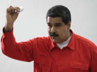 In this photo released by Miraflores Press Office, Venezuela's President Nicolas Maduro shows his ballot after casting a vote for a constitutional assembly in Caracas, Venezuela on Sunday, July 30, 2017. Maduro asked for global acceptance on Sunday as he cast an unusual pre-dawn vote for an all-powerful constitutional assembly that his opponents fear he'll use to replace Venezuelan democracy with a single-party authoritarian system. (Miraflores Press Office via AP)