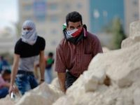 In this Tuesday, Sept. 29, 2015 file photo, Palestinian demonstrators take cover during clashes with Israeli troops near Ramallah, West Bank. Palestinian demonstrators clashed with Israeli troops across the West Bank on Tuesday as tensions remained high following days of violence at Jerusalem’s most sensitive holy site, revered by Jews as the Temple Mount and by Muslims as the Noble Sanctuary. (AP Photo/Majdi Mohammed, File)