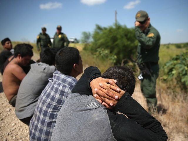 MCALLEN, TX - AUGUST 07: U.S. Border Patrol agents detain undocumented immigrants after they crossed the border from Mexico into the United States on August 7, 2015 in McAllen, Texas. The state's Rio Grande Valley corridor is the busiest illegal border crossing into the United States. Border security and immigration have become major issues in the U.S. presidential campaigns. (Photo by John Moore/Getty Images)