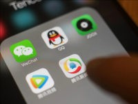 The icons for Tencent Holdings Ltd. applications WeChat, clockwise from top left, QQ, JOOX, Tencent News and Tencent Video are arranged for a photograph on an Apple Inc. iPhone taken in Hong Kong, China, on Wednesday, July 26, 2017. Tencent is scheduled to release second-quarter earnings figures on Aug 16. Photographer: Anthony Kwan/Bloomberg via Getty Images