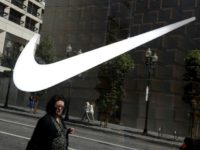 Nike reported a drop in first-quarter earnings on flat sales as heavy promotions in North America again cut into profit