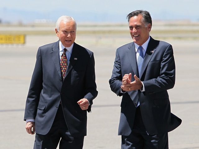 FILE - In this June 8, 2012 file photo, Republican presidential candidate, former Massachusetts Gov. Mitt Romney, right, laughs walking side-by-side with Sen. Orrin Hatch, R-Utah, who met him on the tarmac at Salt Lake International Airport, in Salt Lake City. Local television stations recorded the moment, reminding the state’s GOP voters that their favorite politician, Romney, was in Hatch's corner. (AP Photo/Colin E. Braley, File)
