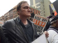 FILE - In this Oct. 24, 2015 file photo, director Quentin Tarantino, center, participates in a rally to protest against police brutality in New York. Speakers at the protest said they want to bring justice for those who were killed by police. Tarantino's new film, "The Hateful Eight," opens in U.S. theaters on Jan. 1, 2016. (AP Photo/Patrick Sison, File