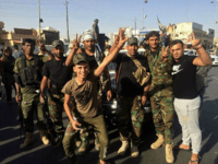 Iraqi security forces and volunteers celebrate in front of Governorate Council Building in Kirkuk, 290 kilometers (180 miles) north of Baghdad, Iraq, Monday, Oct. 16, 2017. A spokesman for Iraq's state-sanctioned militias says they have "achieved all our goals" in retaking areas from Kurdish forces in and around the disputed northern city of Kirkuk. (AP Photo/Emad Matti)