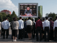 Spectators listen to a television news brodcast of a statment by North Korean leader Kim Jong-Un, before a public television screen outside the central railway station in Pyongyang on September 22, 2017