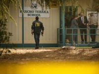 TOPSHOT - FBI agents are seen behind yellow crime scene tape outside Rancho Tehama Elementary School after a shooting in the morning on November 14, 2017, in Rancho Tehama, California Four people were killed and nearly a dozen were wounded, including several children, when a gunman went on a rampage at multiple locations, including a school in rural northern California. / AFP PHOTO / Elijah Nouvelage (Photo credit should read ELIJAH NOUVELAGE/AFP/Getty Images)