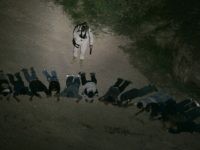 U.S. Border Patrol Borstar agent Dave Artz keeps watch on a group of 13 suspected illegal immigrants as a Blackhawk helicopter keeps a spotlight on the detained group found in the desert southwest of Tucson. (AP Photo/Ross D. Franklin)