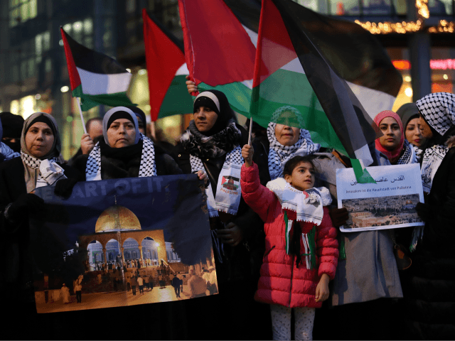 BERLIN, GERMANY - DECEMBER 12: Arabic-speaking protesters, including a woman holding a photograph of the Dome of the Rock in Jerusalem, attend a gathering to protest against the recent announcemment by U.S. President Donald Trump to recognize Jerusalem as the capital of Israel on December 12, 2017 in Berlin, Germany. The protesters waved Palestinian flags and chanted 'Allahu Akbar.' Some also chanted 'Fuck you, Donald Trump.' Today's protest was the fourth in as many days and follows a Sunday protest that drew several thousand demonstators. (Photo by Sean Gallup/Getty Images)