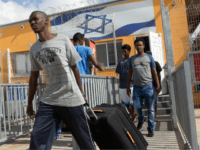 African illegal migrants carry their belongings following their release from the Holot Detention Centre in Israel's Negev desert, on August 25, 2015. Israel began releasing hundreds of African migrants from the detention centre after a court order, but the asylum-seekers were barred from entering two cities. A recent court decision ordered Israel to release the illegal migrants held for more than a year at a detention centre in the Negev desert, a ruling affecting 1,178 of the asylum-seekers. AFP PHOTO/MENAHEM KAHANA (Photo credit should read MENAHEM KAHANA/AFP/Getty Images)