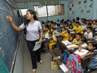 Manila, PHILIPPINES: Teacher Leonora Jusay give a lesson to her 59 students of a Grade 2 class, packed in small classroom that was a former toilet of the government-run Commonwealth Elementary School in Quezon city, suburban Manila, 07 July 2006. The dire situation in this overcrowded public school has become symbolic of the Philippines' educational system as a whole -- too few resources are being used to educate too many students in too little time. The Department of Education estimates that for 2006, the country needed 10,549 new classrooms, 1.22 million desks, 67.03 million textbooks and 12,131 more teachers to deal with the crush. The Philippines has 87 million people, with the population growing at 1.95 percent a year. AFP PHOTO / ROMEO GACAD (Photo credit should read ROMEO GACAD/AFP/Getty Images)