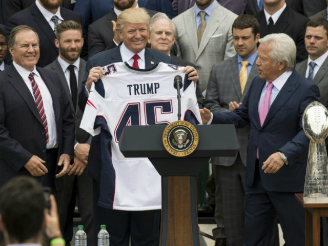 US President Donald Trump holds a jersey given to him by New England Patriots owner Robert Kraft (R) and head coach Bill Belichick (L) alongside members of the team during a ceremony honoring them as 2017 Super Bowl Champions on the South Lawn of the White House in Washington, DC, April 19, 2017. / AFP PHOTO / SAUL LOEB (Photo credit should read SAUL LOEB/AFP/Getty Images)