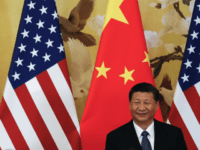 U.S. President Donald Trump waves next to Chinese President Xi Jinping after attending a joint press conference at the Great Hall of the People in Beijing. China's main official news agency is warning U.S.-Chinese relations will face "more pressure and challenges" following President Donald Trump's decision to label Beijing a rival. (AP Photo/Andy Wong, File)