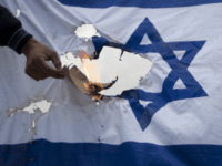 A Palestinian protester burns an Israeli flag after the funeral of Palestinian Milad Said Ayyash, 17, who died of wounds sustained in yesterday's protests in east Jerusalem, Saturday, May 14, 2011.(AP Photo/Sebastian Scheiner)