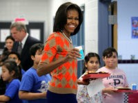 ALEXANDRIA, VA - JANUARY 25: U.S. first lady Michelle Obama joins students at the food line to pick up lunch items at the cafeteria of Parklawn Elementary School January 25, 2012 in Alexandria, Virginia. The first lady, accompanied by Agriculture Secretary Tom Vilsack and celebrity cook Rachael Ray, visited the school to speak to students and parents about the USDA's new nutrition standards for school lunches. (Photo by Alex Wong/Getty Images)