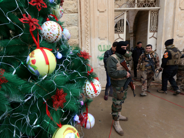 Iraqi security forces stand guard as Christians attend a Christmas Eve service at the Mar Shimoni church in the town of Bartalla near Mosul on December 24, 2016 for the first time since its recapture from Islamic State (IS) jihadists. IS seized Bartalla and swathes of other territory north and west of Baghdad in the summer of 2014, leaving Christians with the grim choices of conversion, paying a tax, fleeing or death. The town was recaptured as part of the massive military operation to retake Mosul, the last IS-held Iraqi city, which was launched on October 17. / AFP / SAFIN HAMED (Photo credit should read SAFIN HAMED/AFP/Getty Images)