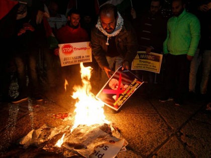 Palestinian demonstrators burn posters of the US president in Bethlehem's Manger Square in protest to him declaring Jerusalem as Israel's capital on December 6, 2017. Abbas said the United States can no longer play the role of peace broker after Donald Trump's decision on Wednesday to recognise Jerusalem as Israel's capital. / AFP PHOTO / Musa AL SHAER (Photo credit should read MUSA AL SHAER/AFP/Getty Images)