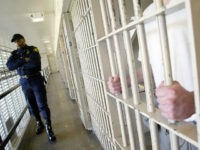 ** ADVANCE FOR WEEKEND, FEB. 5-6 ** Washington state prisons Lt. Clan Jacobs, left, walks through a block of cells at the Washington Corrections Center in Shelton, Wash., Wednesday, Feb. 2, 2005. The prison is the most crowded in the badly crowded state system, and many of the two-bunk cells on this block hold three men. (AP Photo/Ted S. Warren)