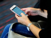 DALLAS, TX - SEPTEMBER 21, 2017: A woman uses her smartphone while waiting to board a plane at the Dallas/Fort Worth International Airport, located roughly halfway between Dallas and Fort Worth, Texas. (Photo by Robert Alexander/Getty Images)