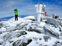 In this Tuesday, March 10, 2015 photo, Ryan Eyestone, 31, of Portland, Maine, makes a photographs near the weather instrument tower of the Mount Washington Observatory on the summit of Mount Washington in New Hampshire. (AP Photo/Robert F. Bukaty)