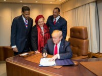 President Donald J. Trump, with Alveda King, center, niece of slain Civil Rights leader Dr. Martin Luther King Jr., and joined by Isaac Newton Farris Jr., left, nephew of Dr. King, and Bruce Levell of the National Diversity Coalition for Trump, right, signs the Martin Luther King Jr. National Historical Park Act, Monday, Jan. 8, 2018, aboard Air Force One, in Atlanta, Ga. (Official White House Photo by Shealah Craighead)