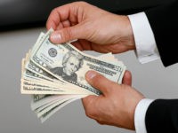 BERLIN, GERMANY - JULY 02: Businessman holding dollar bills in his hands on July 02, 2014, in Berlin, Germany. (Photo by Thomas Trutschel/Photothek via Getty Images)