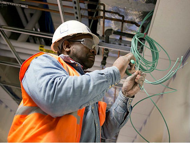 A contractor installs network cable at Skanska USA Building Inc.'s Inova Health System construction site in Lorton, Virginia, U.S., on Thursday, Jan. 3, 2013. Construction spending dipped 0.3 percent in November as gains in housing were not enough to offset declines in nonresidential and public construction, according to Census Bureau data released Jan. 2. Photographer: Andrew Harrer/Bloomberg via Getty Images