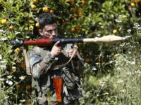 A Hezbollah fighter holds an RPG as he takes his position between orange trees, at the coastal border town of Naqoura, south Lebanon, Thursday, April 20, 2017. Hezbollah organized a media tour along the border with Israel meant to provide an insight into defensive measures established by the Israeli forces along the southern frontier in the past year in preparation for any future conflict. (AP Photo/Hussein Malla)