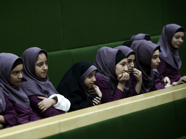 Iranian school girls observe Members of Parliament (MP) discussing a draft to limit photographer's and cameramen's access to cover parliament's open sessions in Tehran on February 27, 2013. The debate took part on the sidelines of a parliamentary session to discuss the annual budget bill which is being presented by the government. AFP PHOTO/BEHROUZ MEHRI (Photo credit should read BEHROUZ MEHRI/AFP/Getty Images)