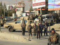 Afghan security personnel keep watch at the entrance of the Intercontinental Hotel, January 20, after Taliban fighters stormed Kabul's landmark hotel and killed at least 25 people, most of them foreigners