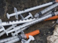 This July 31, 2017, file photo shows discarded syringes in an open-air heroin market that has thrived for decades, slated for cleanup along train tracks a few miles outside the heart of Philadelphia. Philadelphia wants to become the first U.S. city to allow supervised drug injection sites as a way to combat the opioid epidemic, city officials announced Tuesday, Jan. 23, 2018, saying they would seek outside operators to establish one or more safe injection sites. (AP Photo/Matt Rourke, File)