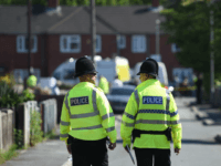 Police officers stand on duty on a cordoned-off road in Fallowfield, Manchester, in northwest England on May 23, 2017, as they search a nearby resdiential property following the May 22 deadly terror attack at the Ariana Grande concert at the Manchester Arena