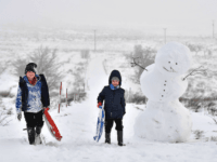 BELFAST, NORTHERN IRELAND - DECEMBER 08: Children off from school due to the weather make their way past a large snowman on Black mountain on December 8, 2017 in Belfast, Northern Ireland. The MET Office has issued a weather warning across the UK for heavy snow with northern and western parts bearing the brunt of the cold snap. (Photo by Charles McQuillan/Getty Images)