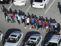 People are brought out of the Marjory Stoneman Douglas High School after a shooting at the school that reportedly killed and injured multiple people on February 14, 2018 in Parkland, Florida. Numerous law enforcement officials continue to investigate the scene. (Photo by Joe Raedle/Getty Images)