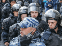 Riot police follow demonstrators walking along Tverskaya street during an unauthorized anti-Kremlin rally called by opposition leader Alexei Navalny, who is serving a 20-day jail sentence, in downtown Moscow on October 7, 2017, President Vladimir Putin's 65th birthday. / AFP PHOTO / Maxim ZMEYEV (Photo credit should read MAXIM ZMEYEV/AFP/Getty Images)