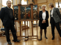 French Culture Minister Francoise Nyssen, right, poses with Henrietta Schubert , second right, and Christopher Bromberg, left, grandchildren of Henry and Hertha Bromberg, next to the oil work entitled 'Triptych of the Crucifixion' attributed to Flemish painter Joachim Patinir during a ceremony of restitution at Culture ministry in Paris, Monday, Feb. 12, 2018. The French state has given back to its rightful owners a 16th century painting spoliated by the Nazis in the Second World War. (AP Photo/Francois Mori)