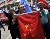 Turkish nationalists holds placards reading 'Turkey save your Brother-China get out from east Turkhistan' and hold a Chinese flag, during a protest to denounce China's treatment of ethnic Uighur Muslims, in front of the Chinese consulate in Istanbul, on July 5, 2015. Turkish media reported restrictions on Muslim Uighurs worshipping and fasting during the holy month of Ramadan. Beijing in turn denied the allegations and demanded that Turkey clarify its statements. AFP PHOTO / OZAN KOSE (Photo credit should read OZAN KOSE/AFP/Getty Images)