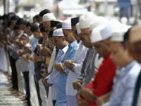 Bangladeshi Muslims living in Malaysia offer a prayer on a street during the first day of Eid al-Fitr, which marks the end of the fasting month of Ramadan in Kuala Lumpur, Malaysia on Sunday, June 25, 2017. (AP Photo/Daniel Chan)