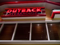 Outback Steakhouse signage is displayed outside of a restaurant location at the Queens Place Mall in the Queens borough of New York, U.S., on Friday, Nov. 9, 2012. Bloomin’ Brands Inc., owner of the Outback Steakhouse restaurant chain, rose 13 percent after raising $176 million in its U.S. initial public offering in August, pricing a reduced number of shares below the proposed range. Photographer: Victor J. Blue/Bloomberg via Getty Images