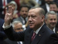 Turkey's President Recep Tayyip Erdogan waves as he arrives to address members of his ruling party at the parliament in Ankara, Turkey, Tuesday, Feb. 20, 2018. Erdogan said Turkish troops involved in an offensive to drive out Syrian Kurdish militiamen from a Syrian enclave will soon begin a siege of the city of Afrin. (AP Photo/Burhan Ozbilici)