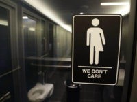 In this Thursday, May 12, 2016 file photo, signage is seen outside a restroom at 21c Museum Hotel in Durham, N.C. Ten states sued the federal government Friday, July 8, 2016 over rules requiring public schools to allow transgender students to use restrooms conforming to their gender identity, joining a dozen other states in the latest fight over LGBT rights. (AP Photo/Gerry Broome, File)