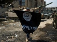 A member of the Iraqi forces holds the Islamic State group flag upside down in Mosul on July 1, 2017