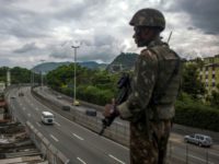 A Brazilian Army soldier stands guard over the "Linha Amarela" (yellow line) road during a joint operation at "Cidade de Deus" (City of God) favela in Rio de Janeiro, Brazil, as Brazil prepares to send in troops to battle gang violence A Brazilian Army soldier stands guard over the "Linha Amarela" (yellow line) road during a joint operation at "Cidade de Deus" (City of God) favela in Rio de Janeiro, Brazil, as Brazil prepares to send in troops to battle gang violence