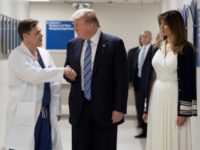 US President Donald Trump shakes hands with doctor Igor Nichiporenko (L) at Broward Health North hospital with First Lady Melania Trump at his side as he pays his respects following the Florida school shooting