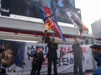 Protesters in Seoul burn a North Korean flag during a rally against the visit by Kim Yong Chol with an eight-member delegation for the Pyeongchang Winter Olympic Games' closing ceremony